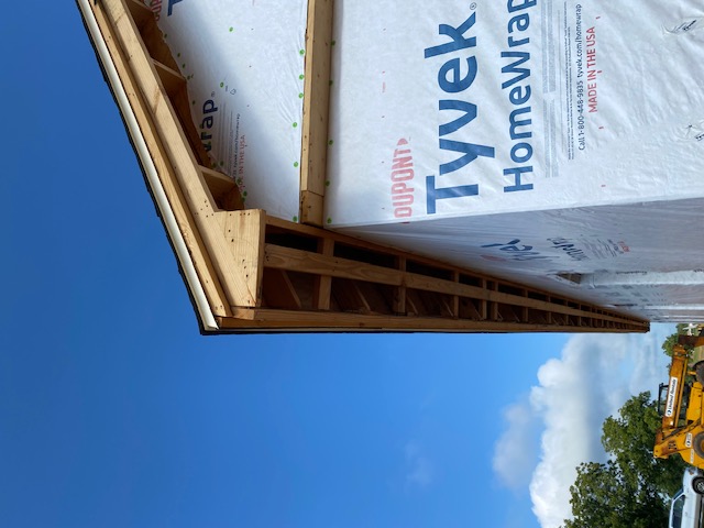 Roof eave framing wrapped in house wrap on a new addition