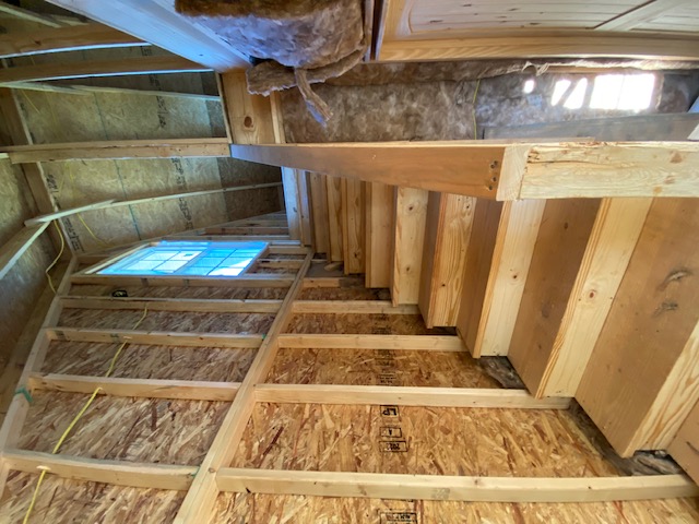 Unfinished stairway framing with exposed studs and insulation