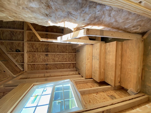 Plywood stairway under a framed attic roofline