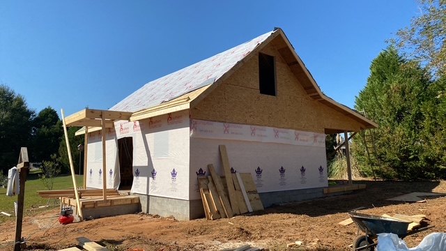 House addition framed and wrapped, roof partially shingled