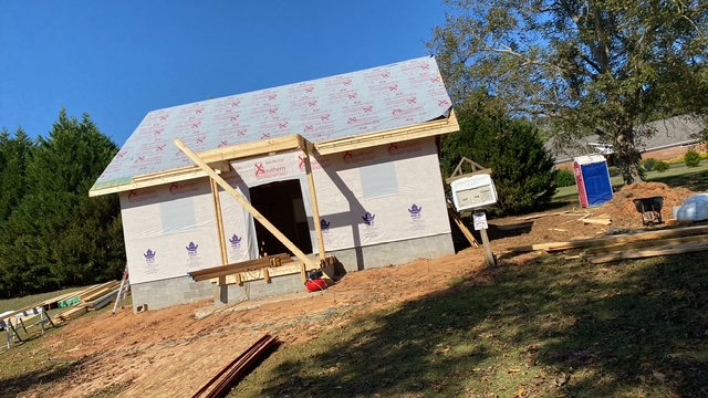 Framed home exterior wrapped in house wrap, porch opening cut in
