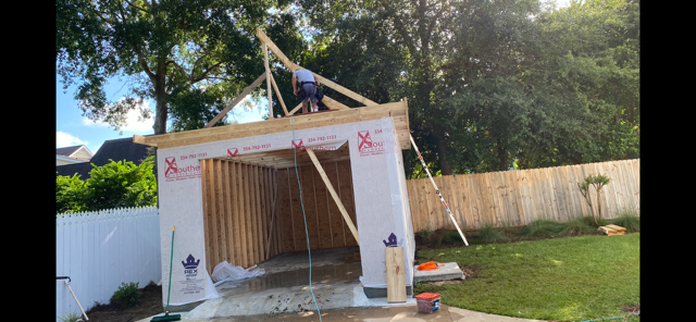 Crew framing the roof trusses of a garage structure