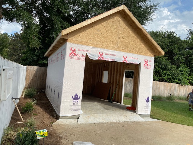 Detached garage framed and wrapped, bay openings cut in