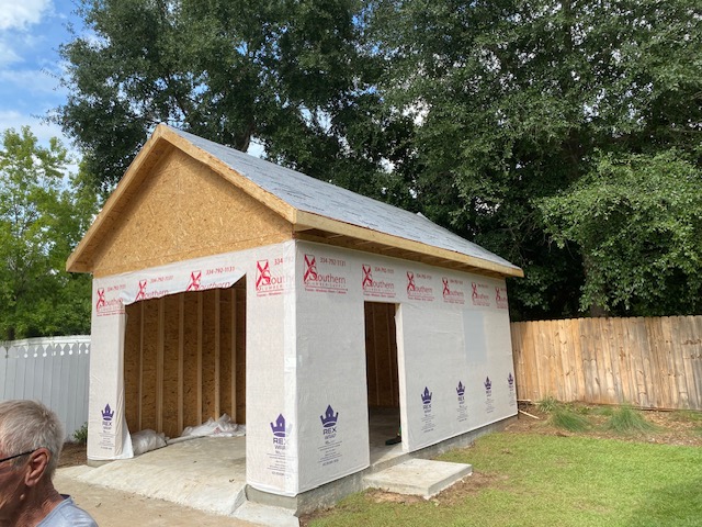 Garage shell wrapped in house wrap, two open bays
