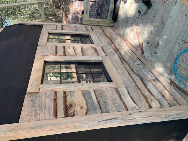 Close-up of rustic board siding around two windows
