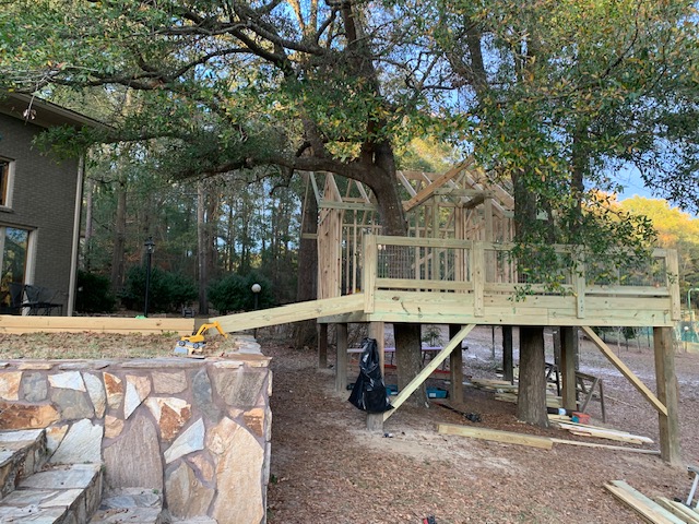 Elevated deck and ramp with a framed structure near a home