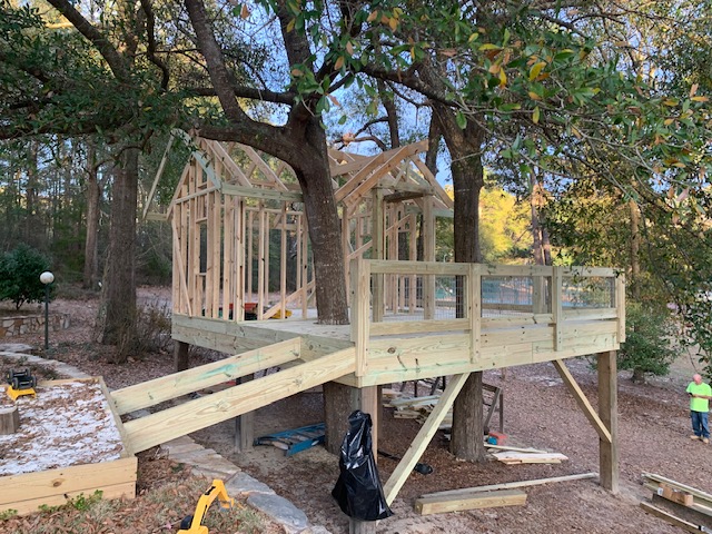 Elevated deck with ramp connecting two framed structures