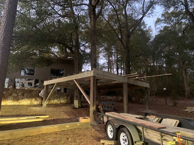 Elevated deck framing beside a stone wall and home at dusk