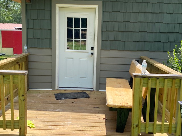 New porch deck addition with door and built-in bench
