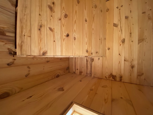 Knotty pine plank ceiling and wall corner in a finished room