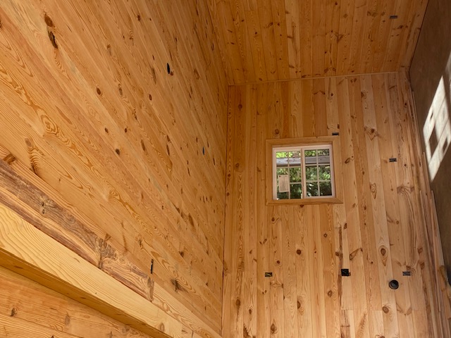 Pine plank ceiling and wall corner with a small window