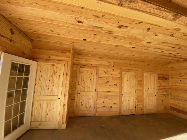 Pine-paneled room with glass door and closet doors