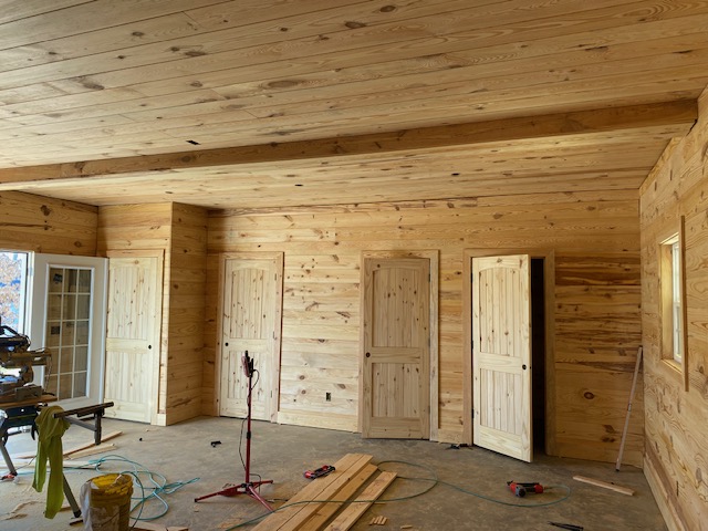 Pine-paneled hallway with four finished wood doors